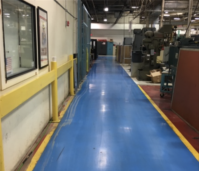 Commercial warehouse facility with blue flooring after water was extracted.