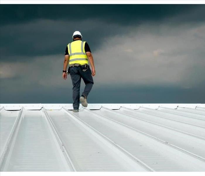 Construction engineer wearing safety uniform inspection metal roofing work for roof industrial concept with copy space